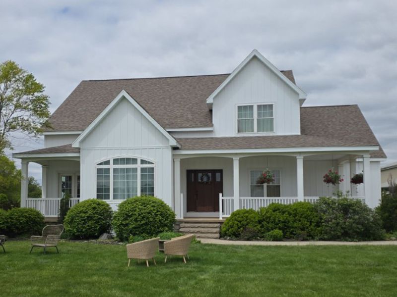 two story home with white board and batten siding after remodel