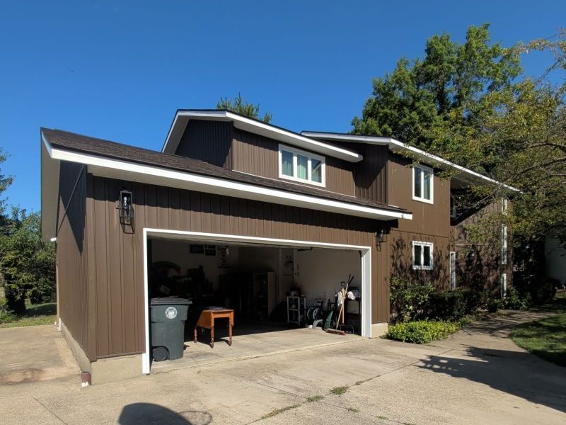 garage wing with new brown vertical siding after remodel