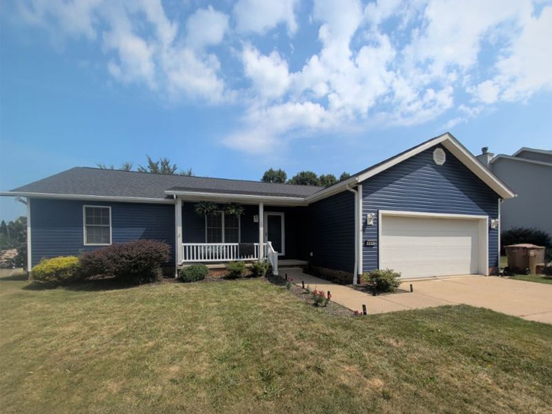 ranch home with navy siding and dark shingle roof after remodel