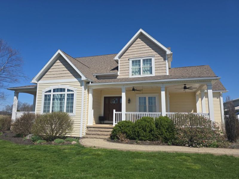 two story home with dated yellow lap siding before remodel
